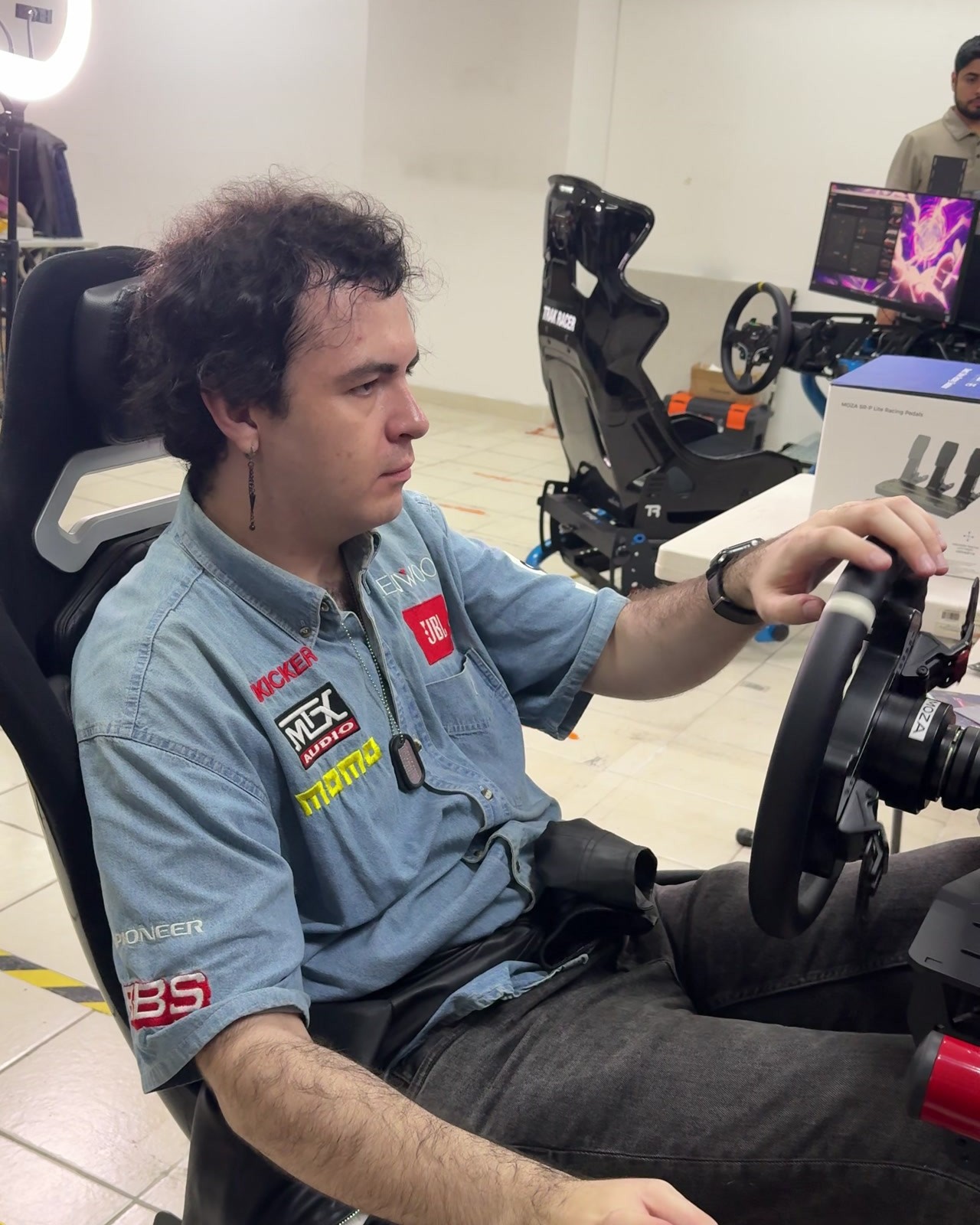 David Tapia sentado en un simulador de carreras en las oficinas de Quantum Imports.