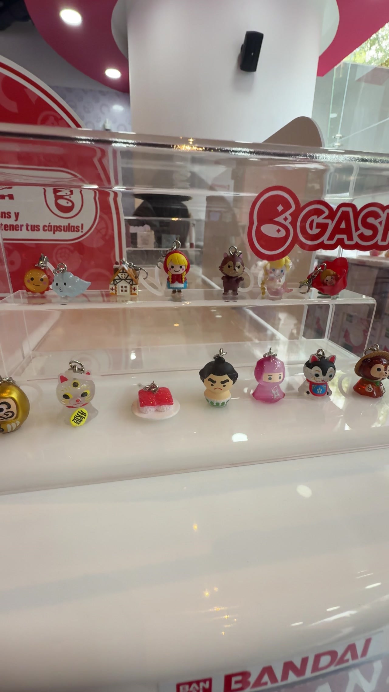 Vitrina con figuras de gashapon sobre una repisa blanca en la tienda de Bandai Namco en la Ciudad de México.