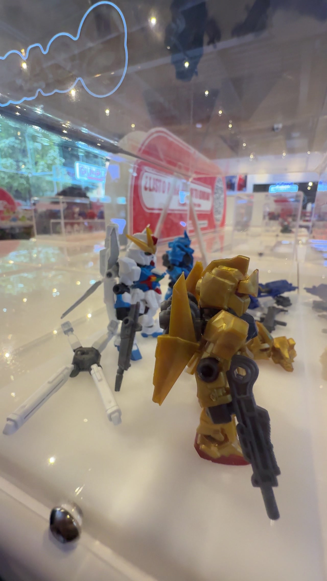 Figuras de Gunpla de Gundam, una de ellas dorada, dentro de una vitrina de la tienda de Bandai Namco en la Ciudad de México.